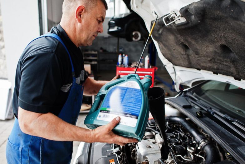 Person Checking the Oil of an Engine